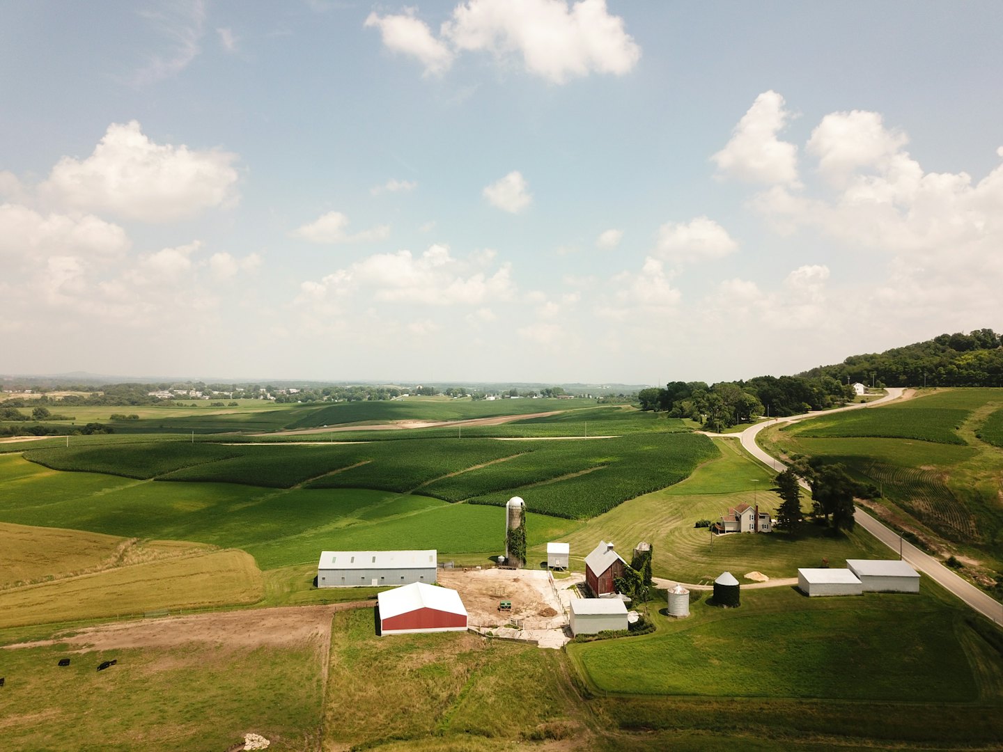 Pohľad zhora na farmársky komplex s stodolami a silami.