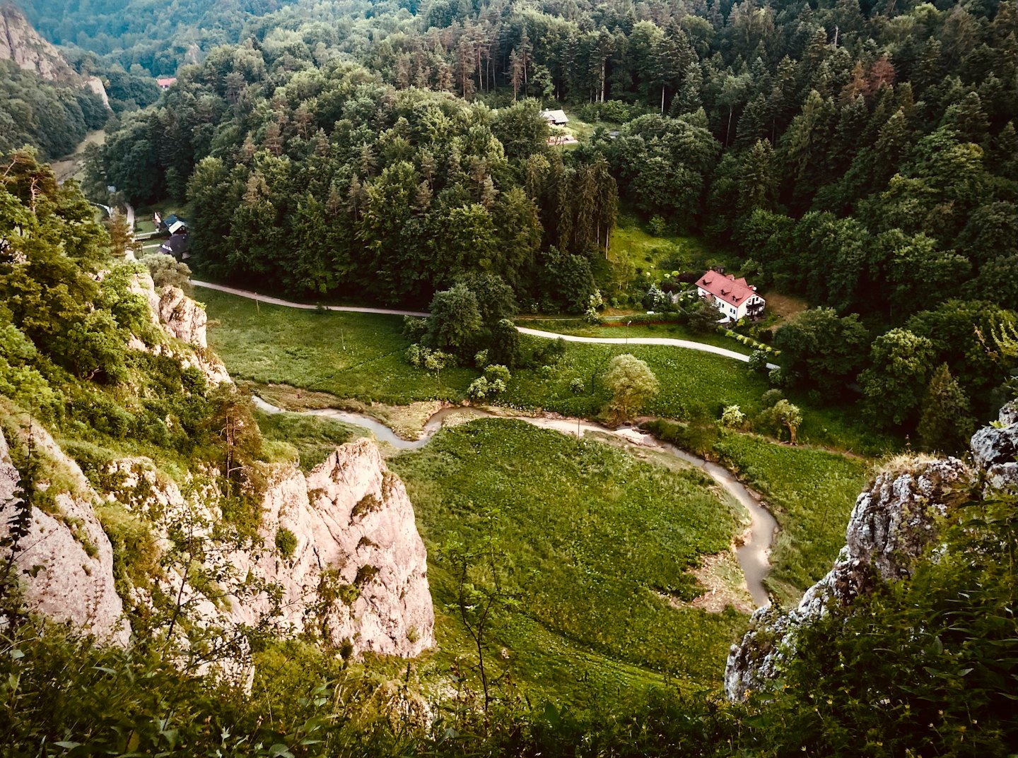 Bielý dom s červenou strechou stojí pri riečnom údolí.